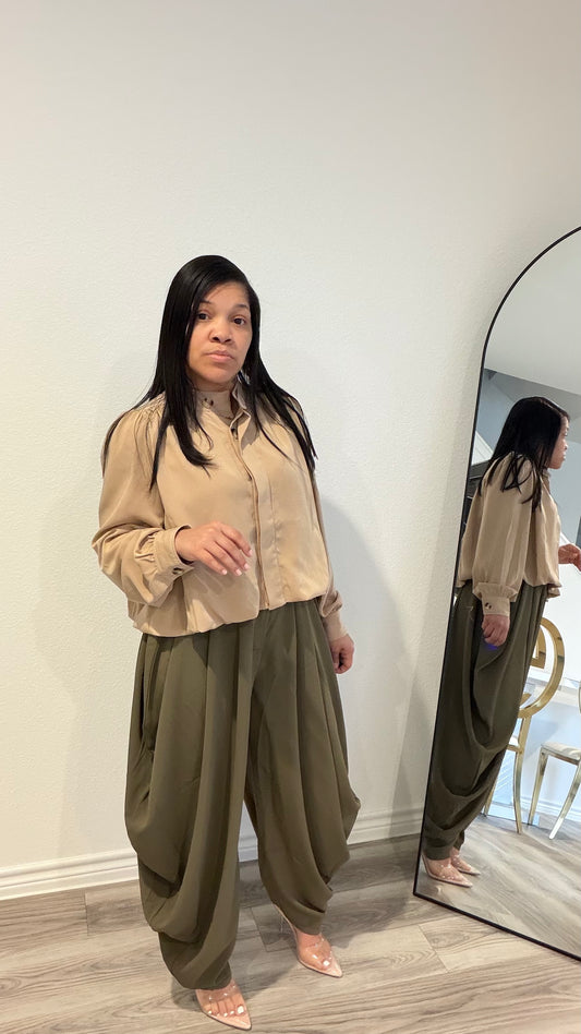 Woman wearing draped pants with gathered detailing and a relaxed silhouette.