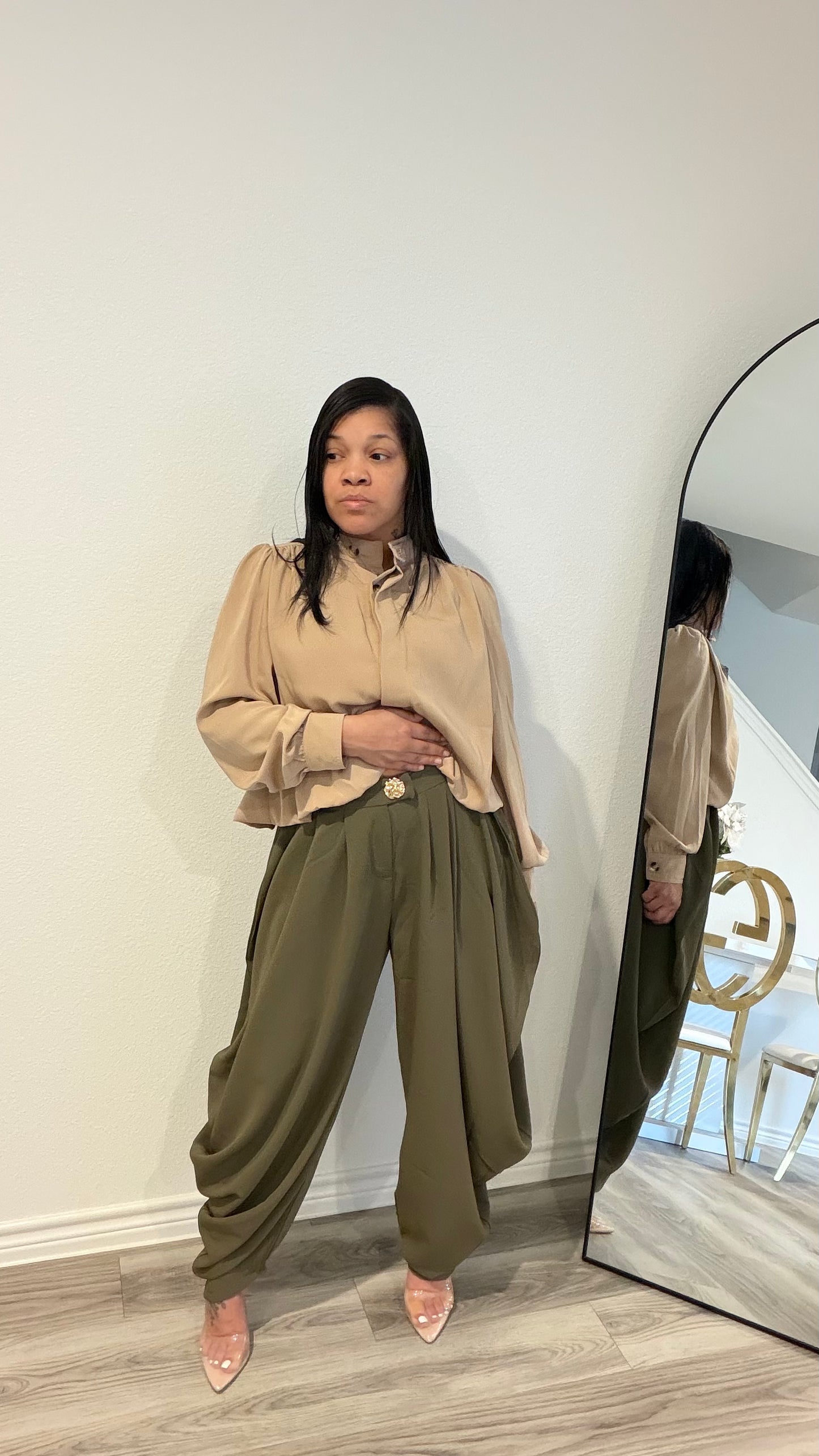 Woman wearing draped pants with gathered detailing and a relaxed silhouette.