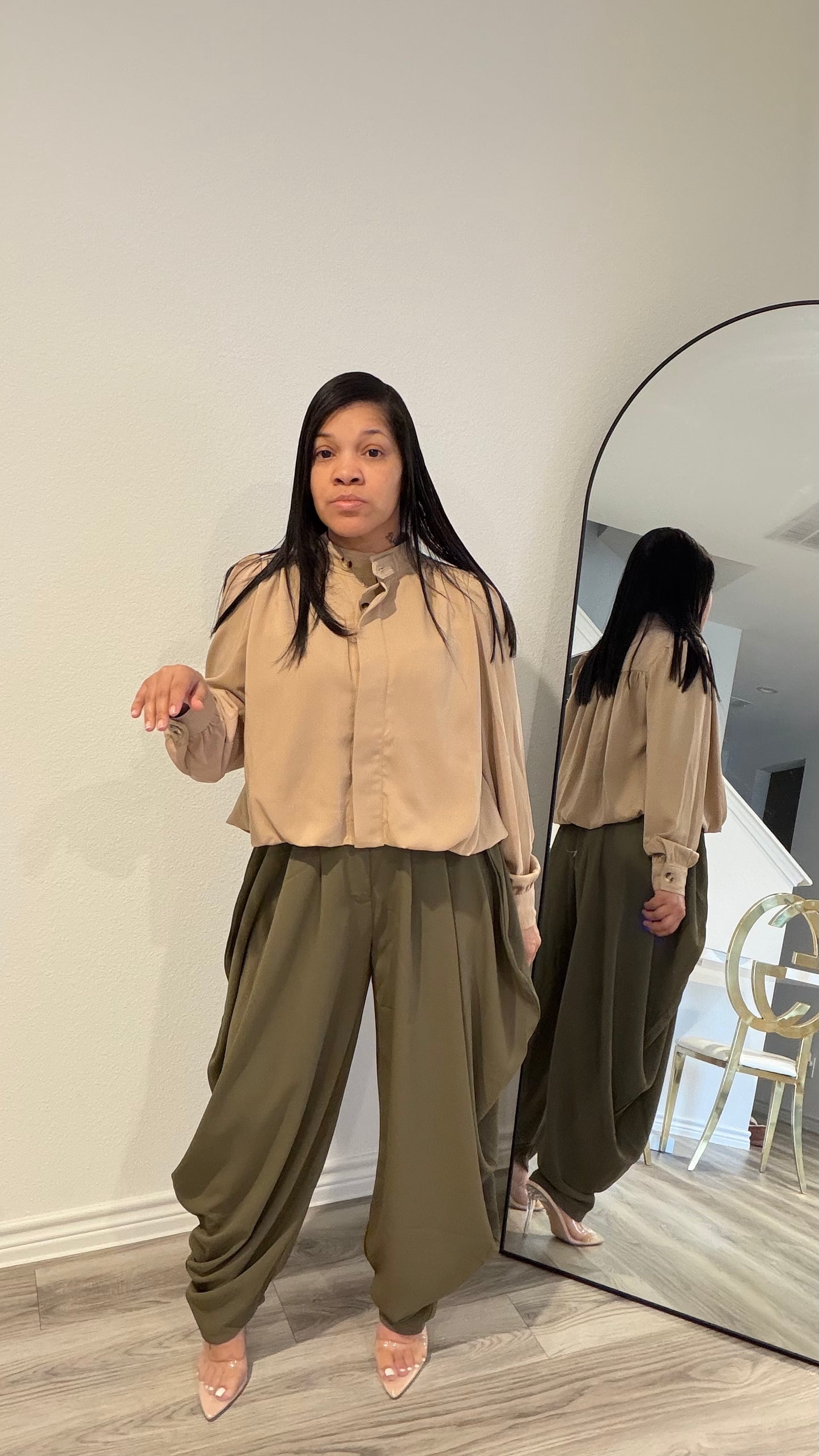 Woman wearing draped pants with gathered detailing and a relaxed silhouette.