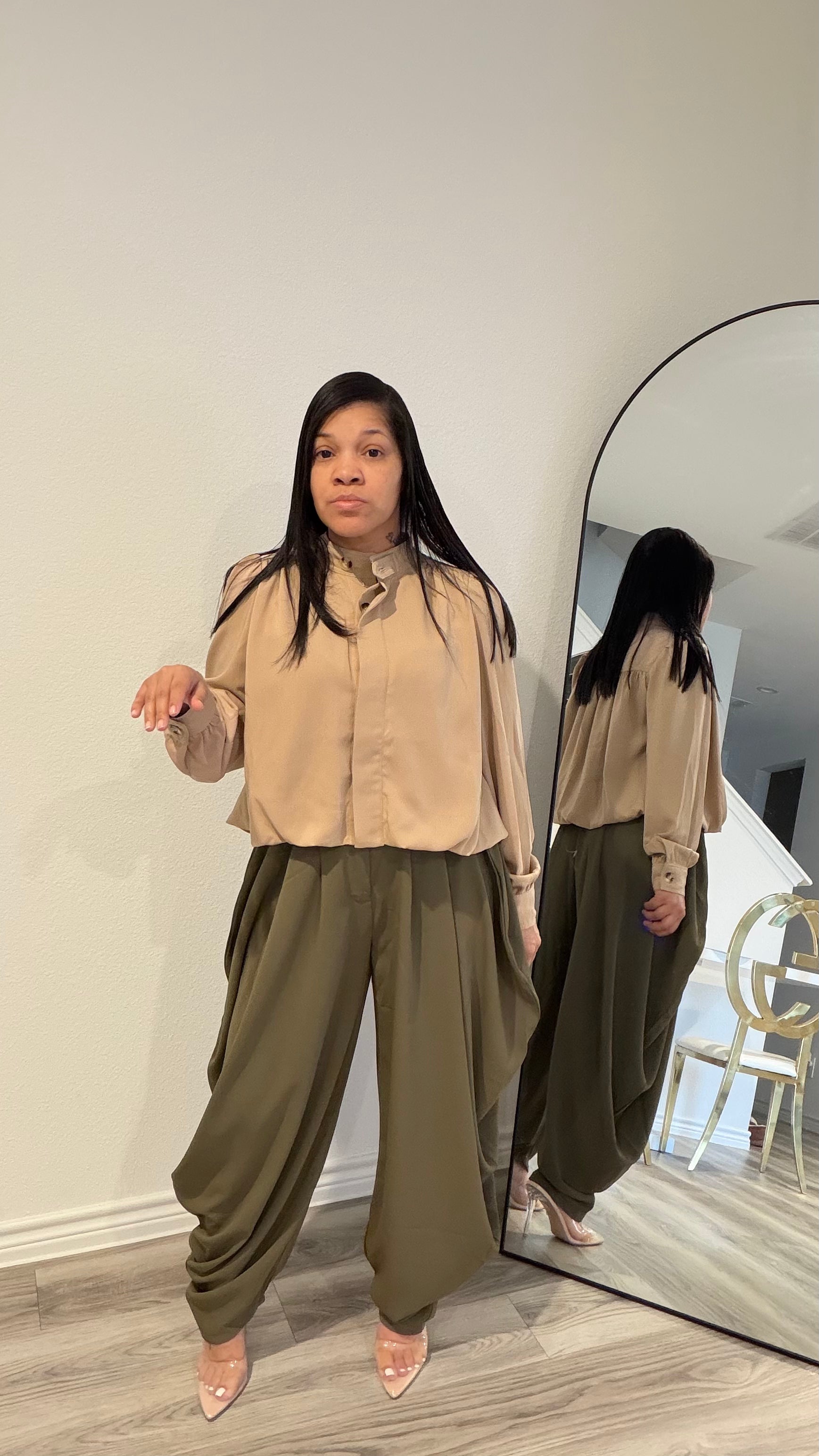 Woman wearing draped pants with gathered detailing and a relaxed silhouette.