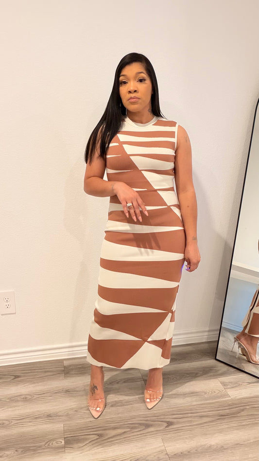 Woman wearing an abstract print column dress with a sleek, straight silhouette.