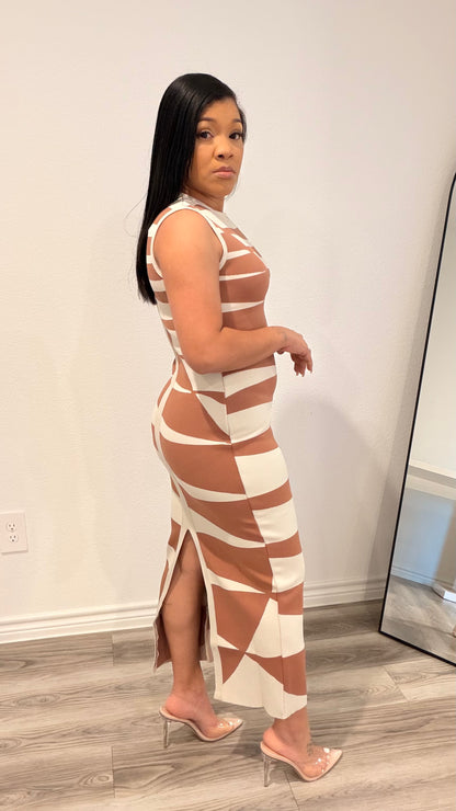 Woman wearing an abstract print column dress with a sleek, straight silhouette.