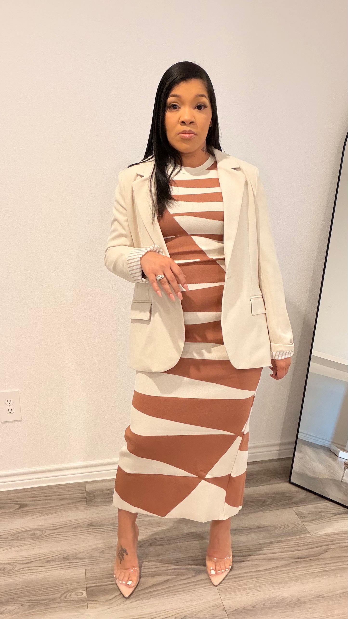 Woman wearing an abstract print column dress with a sleek, straight silhouette.