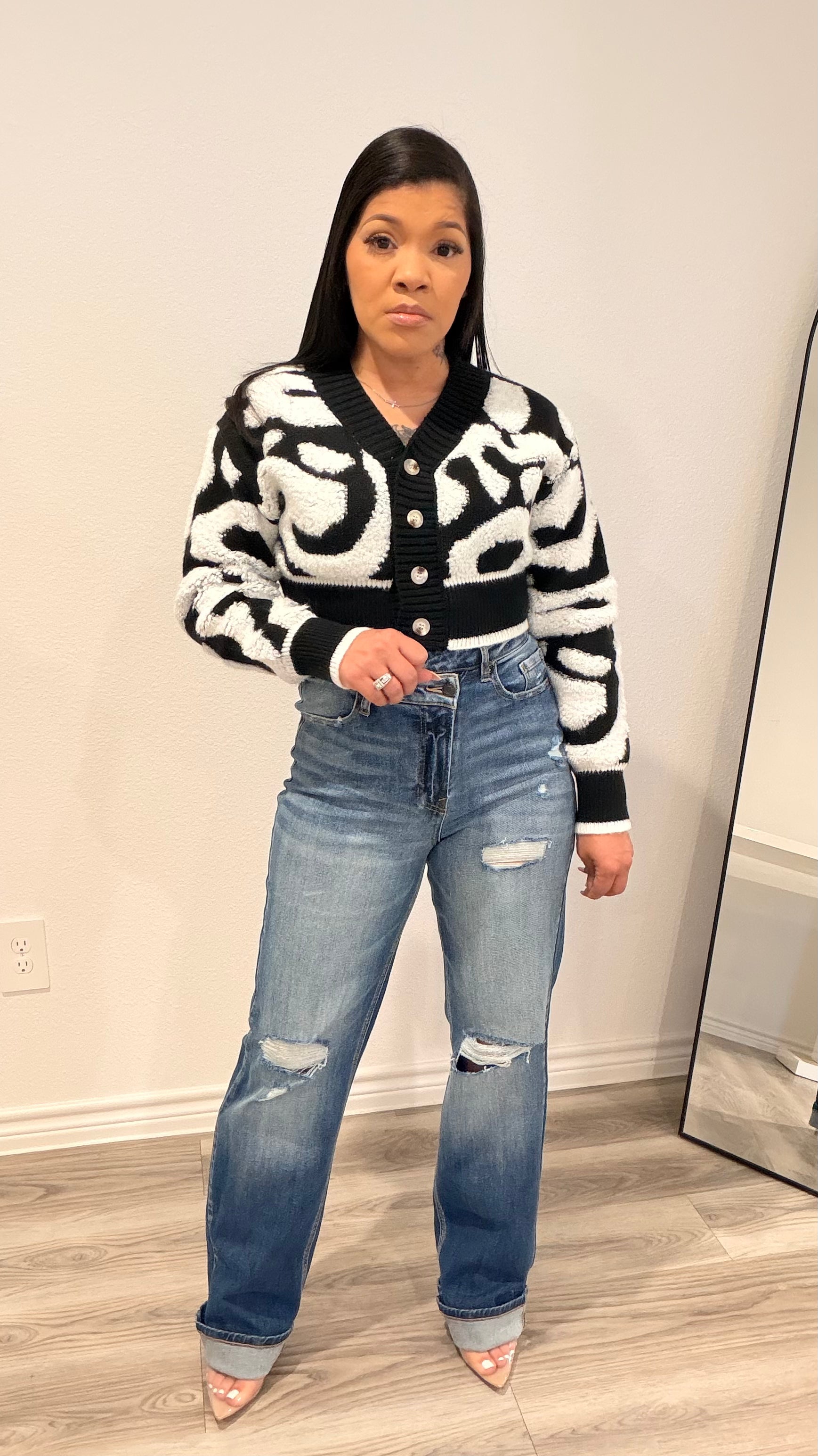 Woman wearing straight-leg jeans with an off-center waistband detail.