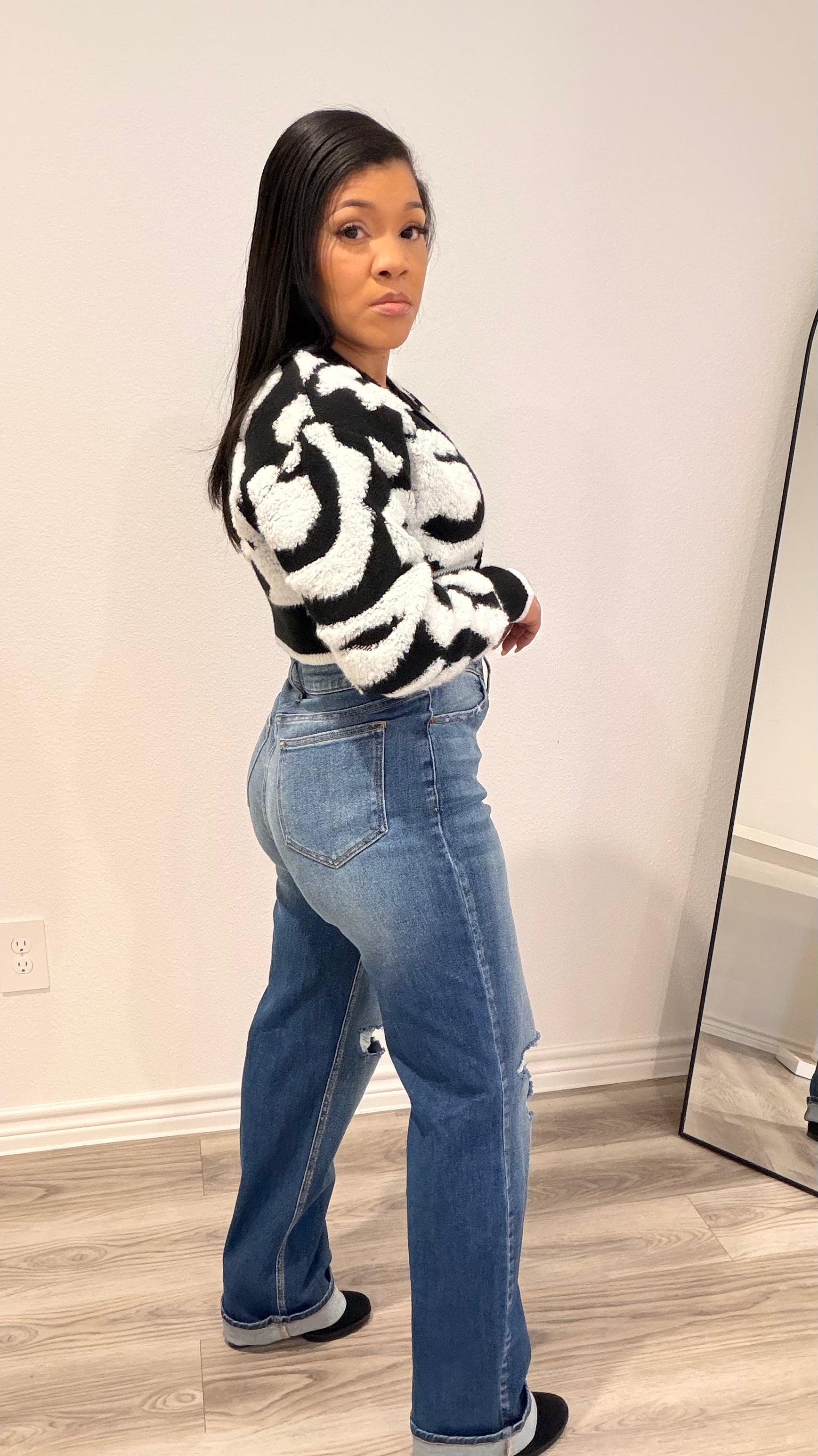 Woman wearing a cropped color-block cardigan layered over a fitted top.