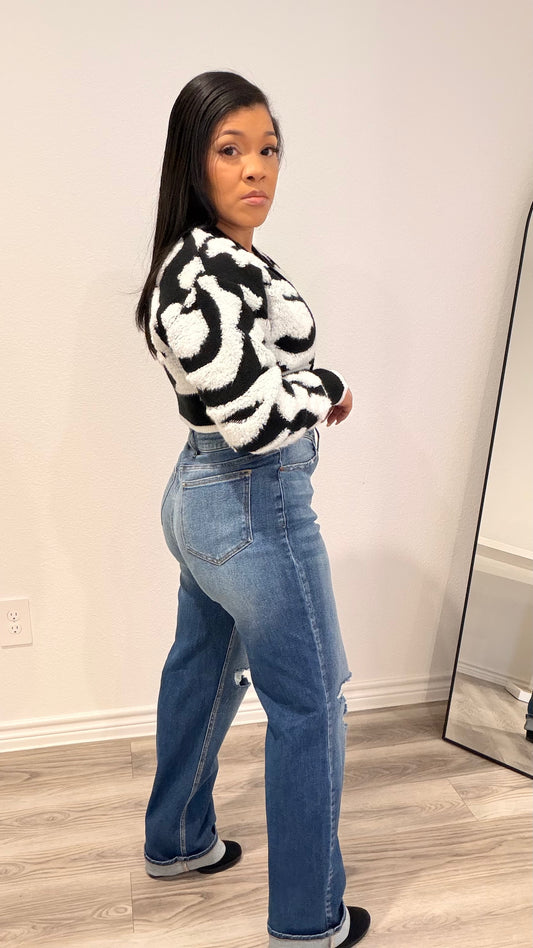 Woman wearing a cropped color-block cardigan layered over a fitted top.