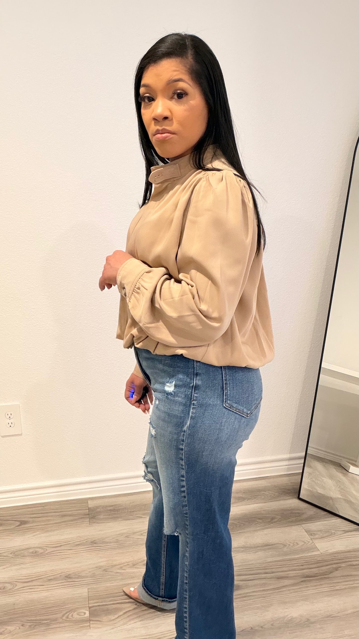 Woman wearing a woven blouse with a relaxed fit and softly shaped hem.