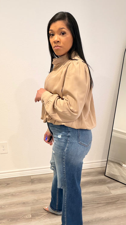 Woman wearing a woven blouse with a relaxed fit and softly shaped hem.