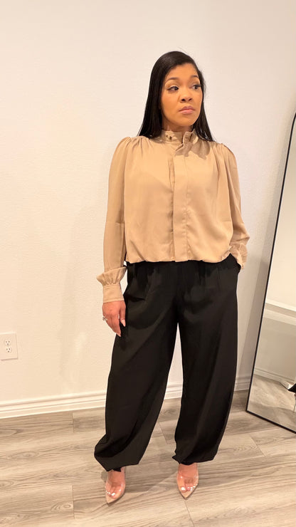 Woman wearing a woven blouse with a relaxed fit and softly shaped hem.