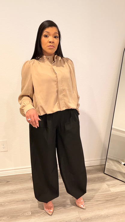 Woman wearing barrel-leg trousers with a relaxed, sculpted silhouette.