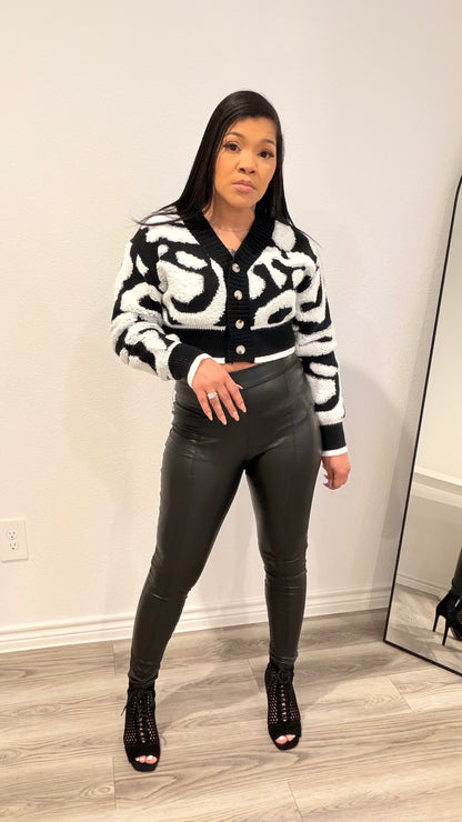 Woman wearing a cropped color-block cardigan layered over a fitted top.