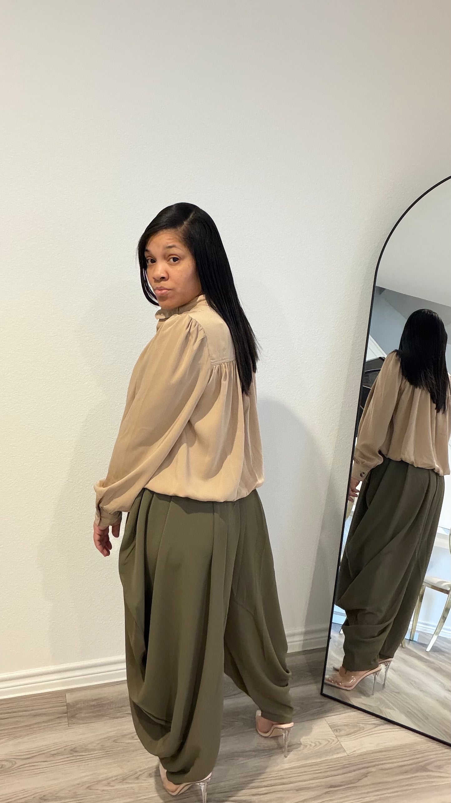 Woman wearing draped pants with gathered detailing and a relaxed silhouette.