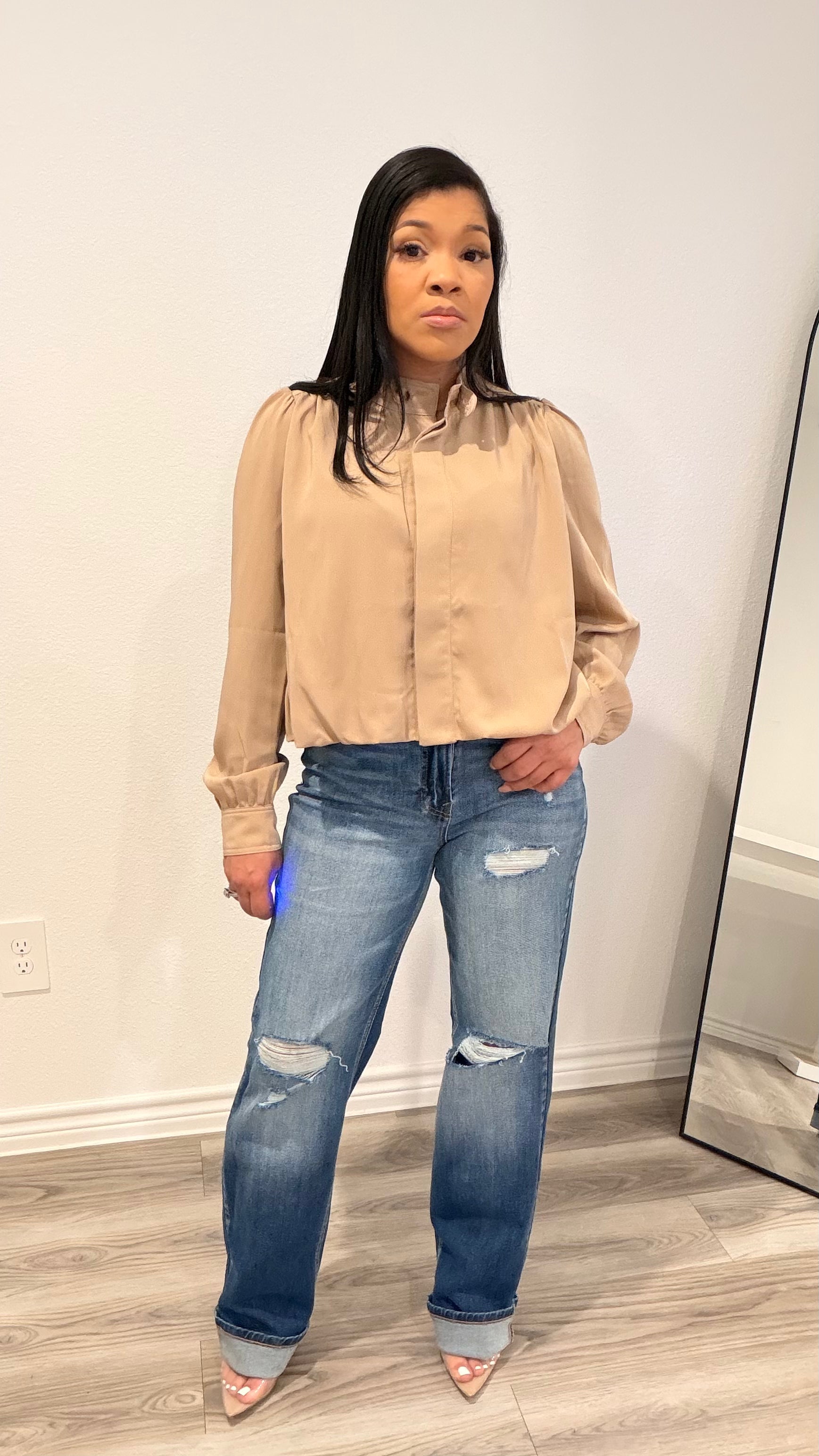 Woman wearing straight-leg jeans with an off-center waistband detail.