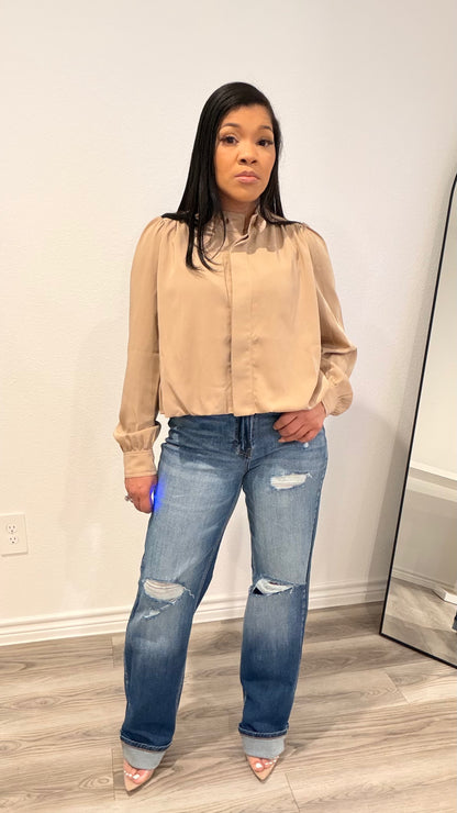 Woman wearing straight-leg jeans with an off-center waistband detail.